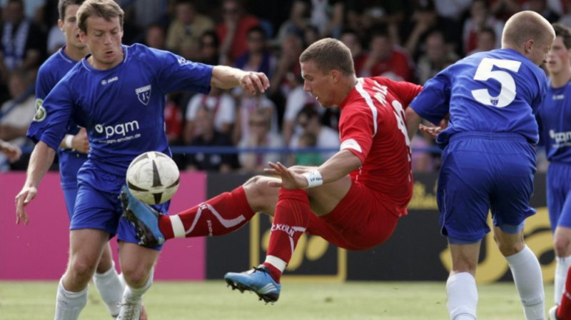 Lukašs Podoļskis ("1. FC Köln") starp diviem
"Kickers Emden" futbolistiem
Foto: AP