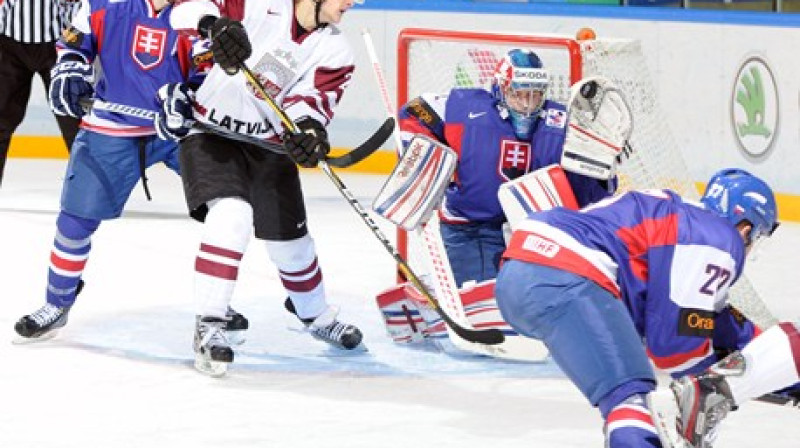 Teodors Bļugers vārtu priekšā cīņā ar slovāku aizsargu.
Foto: Richard Wolowicz/HHOF-IIHF Images