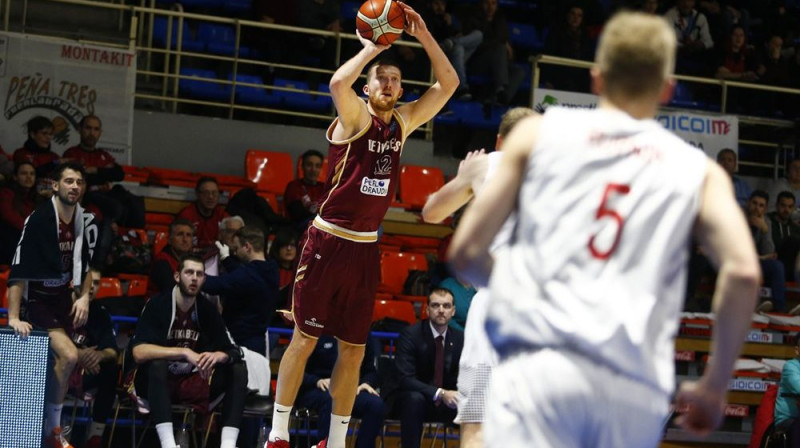 Sandis Buškevics uz rezervistu soliņa noskatās Sauļa Kulvieta tālmetienu. Foto: FIBA