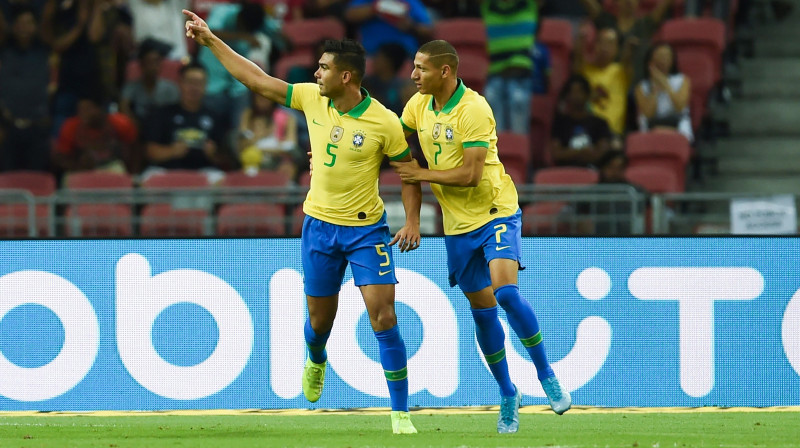 Brazīlijas izlases futbolisti Kazemiru (no kreisās) un Rišarlisons priecājas pēc vārtu guvuma. Foto: AFP/Scanpix