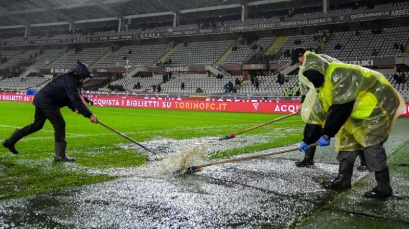 Darbinieki tīra pielijušo laukumu pirms "Torino" un "Inter" spēles Turīnā. Foto: AFP/Scanpix