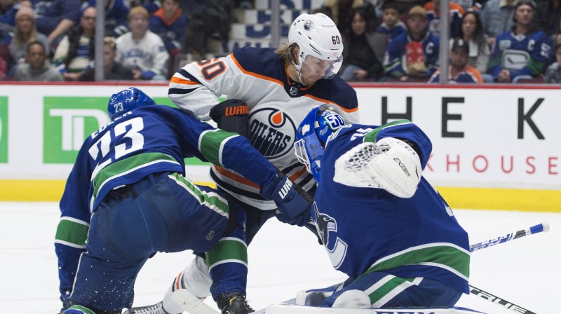 Markuss Granlunds (vidū) pret savu bijušo komandu Vankūveras "Canucks". Foto: AP/Scanpix