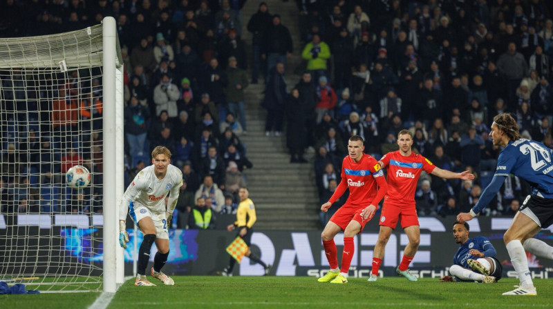 Roberts Uldriķis (pirmais labajā malā) nolūkojas kā bumba ielido Ķīles "Holstein" vārtos. Foto: Friso Gentsch/DPA/Picture-Alliance/Scanpix